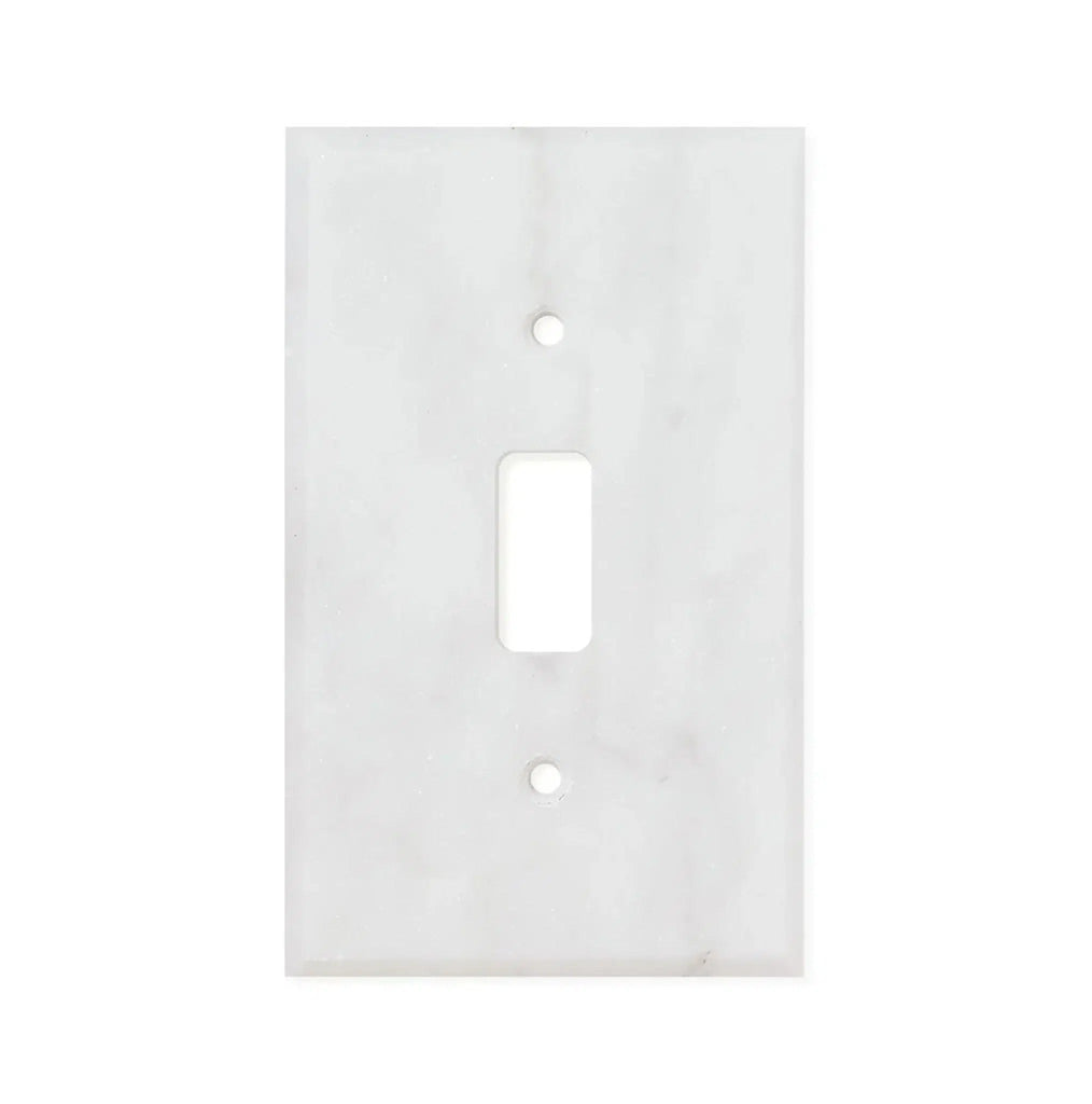 The Carrara White Marble Single TOGGLE Plate Switch Wall Plate, offered by SurfacesGalore, is crafted from authentic natural stone and features a rectangular cutout for the switch along with two screw holes.