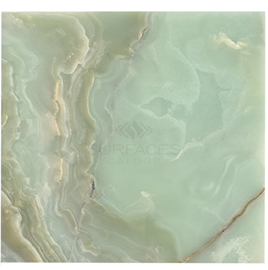 The Green Onyx Premium Marble 12X12 Polished from SurfacesGalore features a stunning marble surface with light green and beige swirls, showcasing natural elegant patterns and textures. Text on image reads "SurfacesGalore: Premium Tile Options.