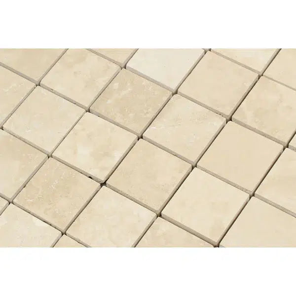 Close-up view of the Ivory (Light) Travertine 2X2 Brick Mosaic Filled and Honed by SurfacesGalore, featuring small, square tiles in a beige pattern. Each tile has a slightly different tone, creating a textured appearance. The grout lines form a grid, neatly separating each tile.