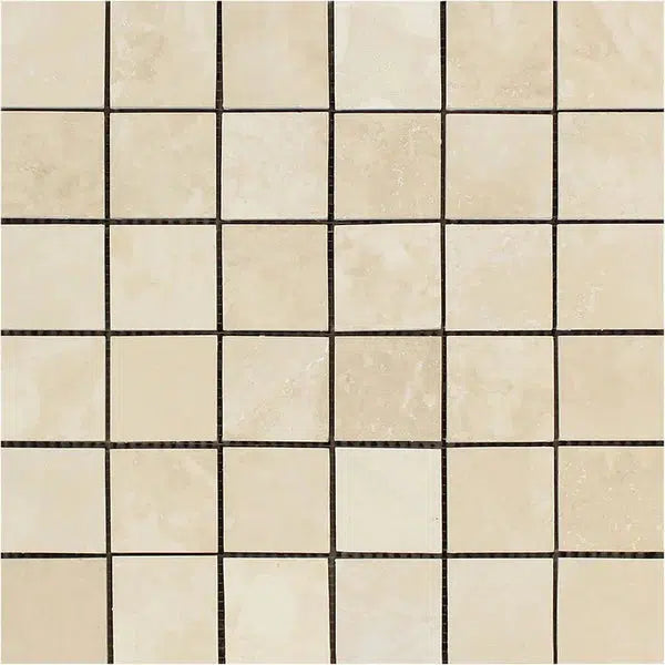 SurfacesGalore's Ivory (Light) Travertine 2X2 Brick Mosaic Filled and Honed creates a sophisticated square tile mosaic pattern featuring a grid of beige and light brown tones. The subtle elegance of the Ivory Travertine, with its unique shades and textures, forms a varied yet cohesive look, while black grout lines distinctly separate each individual tile.