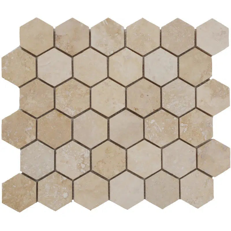 A mosaic tile sheet from SurfacesGalore features beige and light brown hexagonal tiles arranged in a uniform pattern. The natural stone texture of the Ivory (Light) Travertine 2X2 Hexagon Mosaic Filled and Honed, with its varying shades and subtle white veining, adds depth and sophistication to any space.