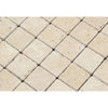 Close-up of SurfacesGalore's Ivory (Light) Travertine 2X2 Mosaic Tumbled tiles arranged in a diagonal grid. The square-shaped tiles exhibit a slightly rough texture, with natural variations in color and surface markings.