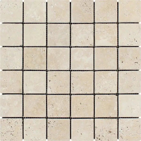 A grid of SurfacesGalore's Ivory (Light) Travertine 2X2 Mosaic Tumbled tiles, featuring slight variations in color and texture, arranged neatly in rows and columns. These tiles showcase a natural stone appearance, delivering a rustic and earthy feel. The thin, uniform grout lines between the tiles complete the look.