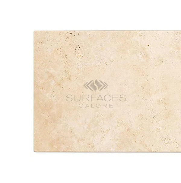 An Ivory (Light) Travertine 3X6 (Cross-Cut) Tumbled marble slab with the "SurfacesGalore" logo displayed on its surface, reminiscent of fine beige marble.