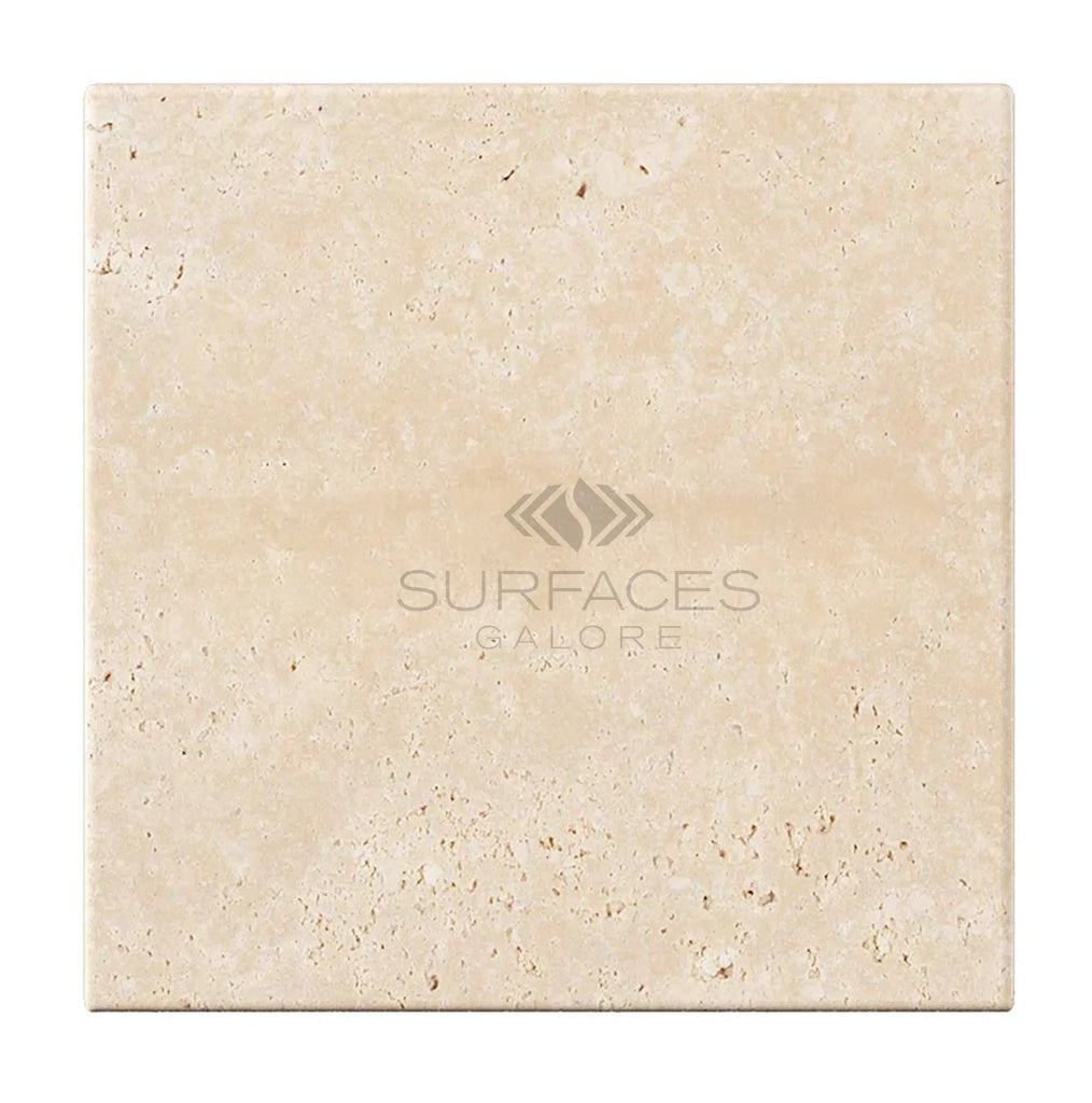 An Ivory (Light) Travertine 4x4 (Cross-Cut) Tumbled tile, adorned with the SurfacesGalore logo, offers a premium finish ideal for elegant spaces.