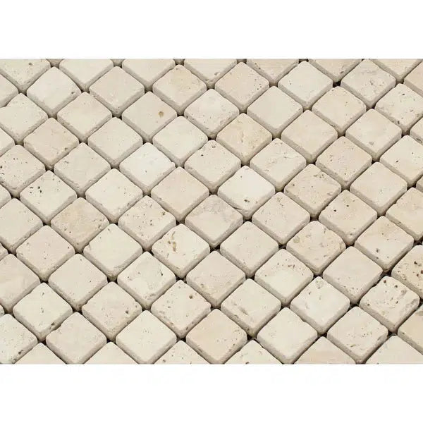 A close-up view of an Ivory (Light) Travertine 5/8X5/8 Mosaic Tumbled wall or surface from SurfacesGalore, featuring small, square tiles arranged in a neat, grid-like pattern. These tiles have a slightly rough texture and varying shades, giving the surface a natural, rustic appearance.