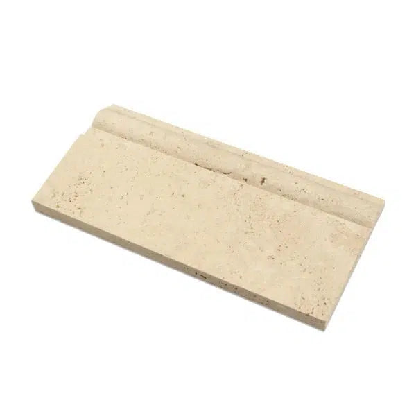 An Ivory (Light) Travertine 5X12 Baseboard Trim Liner Honed by SurfacesGalore, featuring a textured surface and a groove along one edge, is displayed against a white background. This beige rectangular trim stone is perfect for Surfaces Galore projects due to its design for fitting or stacking with other pieces.