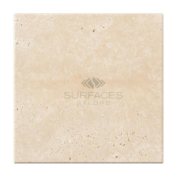 A square Ivory (Light) Travertine tile in a 6x6 size, cross-cut and tumbled, featuring the "SurfacesGalore" logo centrally placed on it, reminiscent of the refined appeal seen in Light Travertine Tiles.