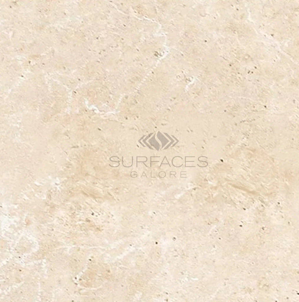 An 8x16 ivory travertine tile with a smooth, slightly textured surface and subtle speckles. Text in center reads "SURFACES GALORE." Perfect for those seeking elegant Light Travertine Tiles.