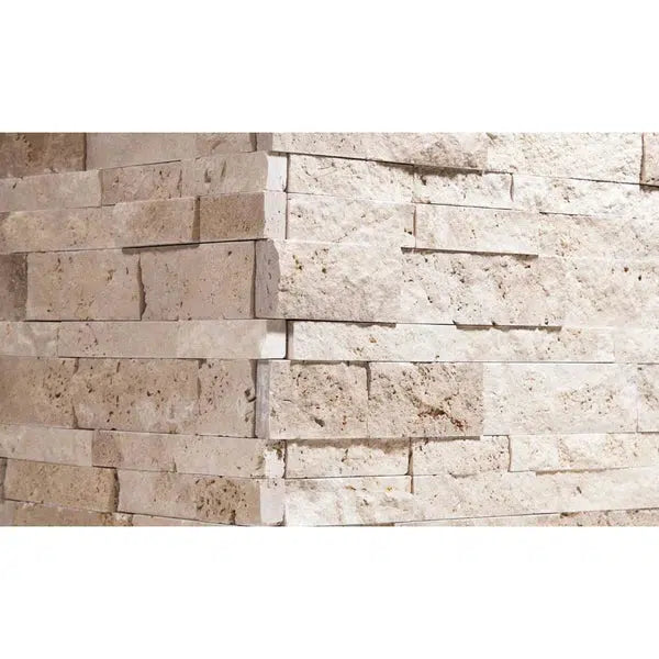 Close-up view of a corner composed of rough-textured, rectangular, beige stone bricks stacked unevenly, showcasing the rustic, three-dimensional elegance of SurfacesGalore's Ivory (Light) Travertine Ledger-Panel ("Z" Split-Panel) CORNER Split-Faced.