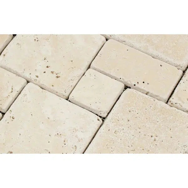 A close-up of the Ivory (Light) Travertine OPUS Mini-Pattern (4 pcs.) Mosaic (Interlocking) Tumbled shows a sophisticated textured beige stone tile mosaic, featuring variously sized rectangles and squares arranged in an interlocking pattern. The premium travertine stones have a rough finish with small pits and imperfections, enhancing their natural, rustic appearance. Available at SurfacesGalore.