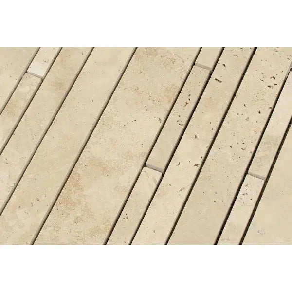 A close-up view of a wall featuring the SurfacesGalore Ivory (Light) Travertine Random Strip Mosaic Filled and Honed tiles arranged in a staggered vertical pattern. The surfaces display natural variation in color and texture, with some tiles showing small holes and fossil-like markings typical of travertine.