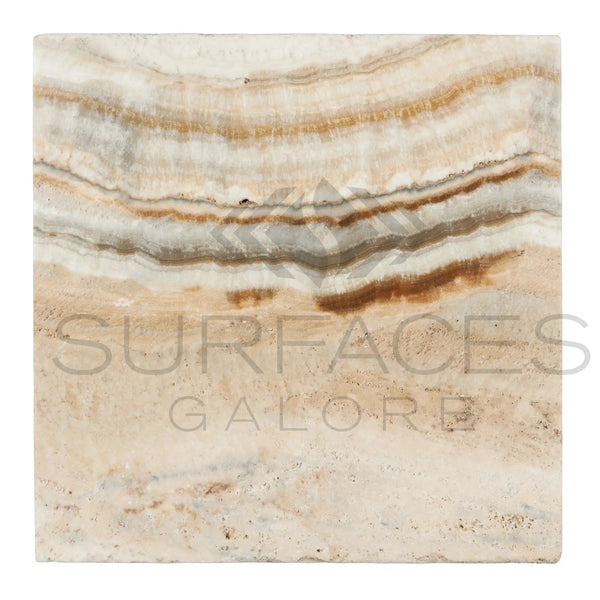 A 12x12 sample of tumbled La Travonya Travertine from SurfacesGalore, showcasing a polished natural stone with beige, brown, and white wavy layers. The pattern is irregular and organic with visible striations, highlighting the stone’s intricate natural design and durability. The brand name "SurfacesGalore" is subtly visible across the sample.