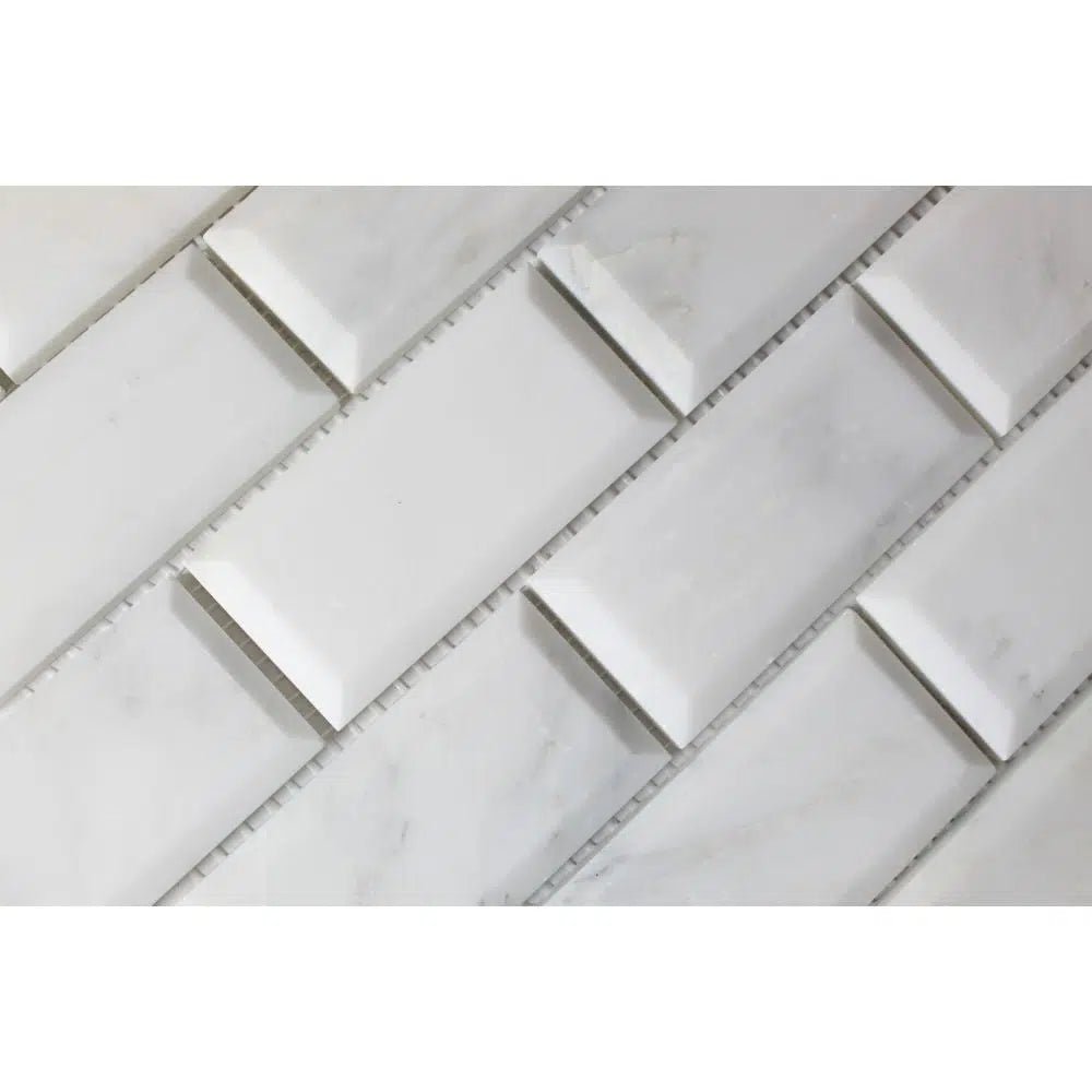 Close-up of SurfacesGalore Oriental White / Asian Statuary 2x4 Brick Deep-Beveled Marble Mosaic Polished-Honed tiles arranged diagonally, with thinner elevated tiles interspersed between them, creating a classic aesthetic.