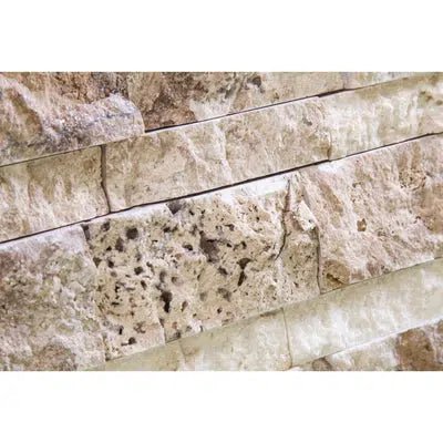 Close-up view of a textured stone wall with beige and light brown tones, showcasing the luxurious Philadelphia Travertine Ledger-Panel ("Z" Split-Panel) Mosaic Split-Faced from SurfacesGalore. The varied shapes and natural patterns emphasize the elegance of this premium travertine product.