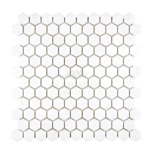 The Thassos White (Greek) 1X1 Hexagon Mosaic Marble Polished-Honed from SurfacesGalore features a hexagonal white tile pattern with grey grout lines, creating a honeycomb design on a square tile sheet.