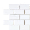 A section of Thassos White (Greek) 1X2 Brick Mosaic Marble Polished-Honed tiles by SurfacesGalore, arranged in a brick pattern against a white background, creating a luxurious look.