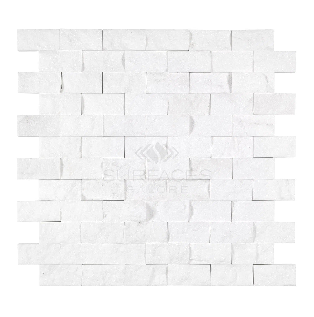 Thassos White (Greek) 1X2 Brick Mosaic Marble Split-Faced tiles from SurfacesGalore, arranged in a staggered pattern, featuring a crystalline texture with the brand logo watermark at the center.