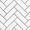 The herringbone pattern of SurfacesGalore's Thassos White (Greek) 1X3 Herringbone Mosaic Marble Polished-Honed tiles with gray grout lends a touch of elegance to any space.