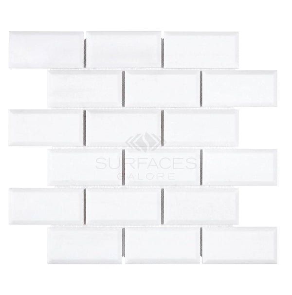 White rectangular tiles arranged in a brick pattern on a white background exude a luxurious look reminiscent of the Thassos White (Greek) 2X4 Deep-Beveled Brick Mosaic Marble Polished-Honed by SurfacesGalore.