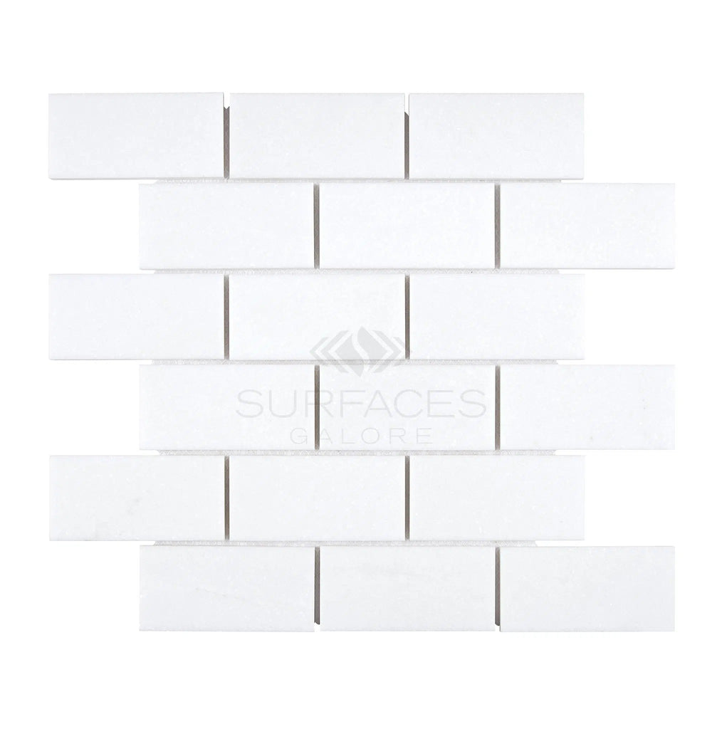 A pattern of Thassos White (Greek) 2X4 Straight-Edged Brick Mosaic Marble Polished-Honed tiles from SurfacesGalore arranged in a horizontal brick layout.