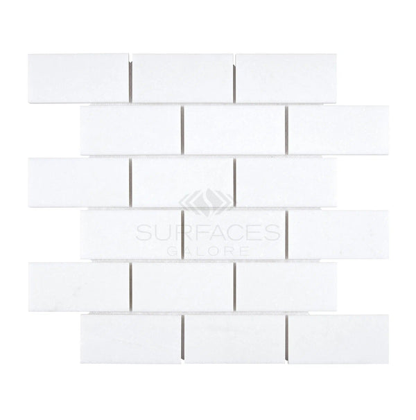 A pattern of Thassos White (Greek) 2X4 Straight-Edged Brick Mosaic Marble Polished-Honed tiles from SurfacesGalore arranged in a horizontal brick layout.