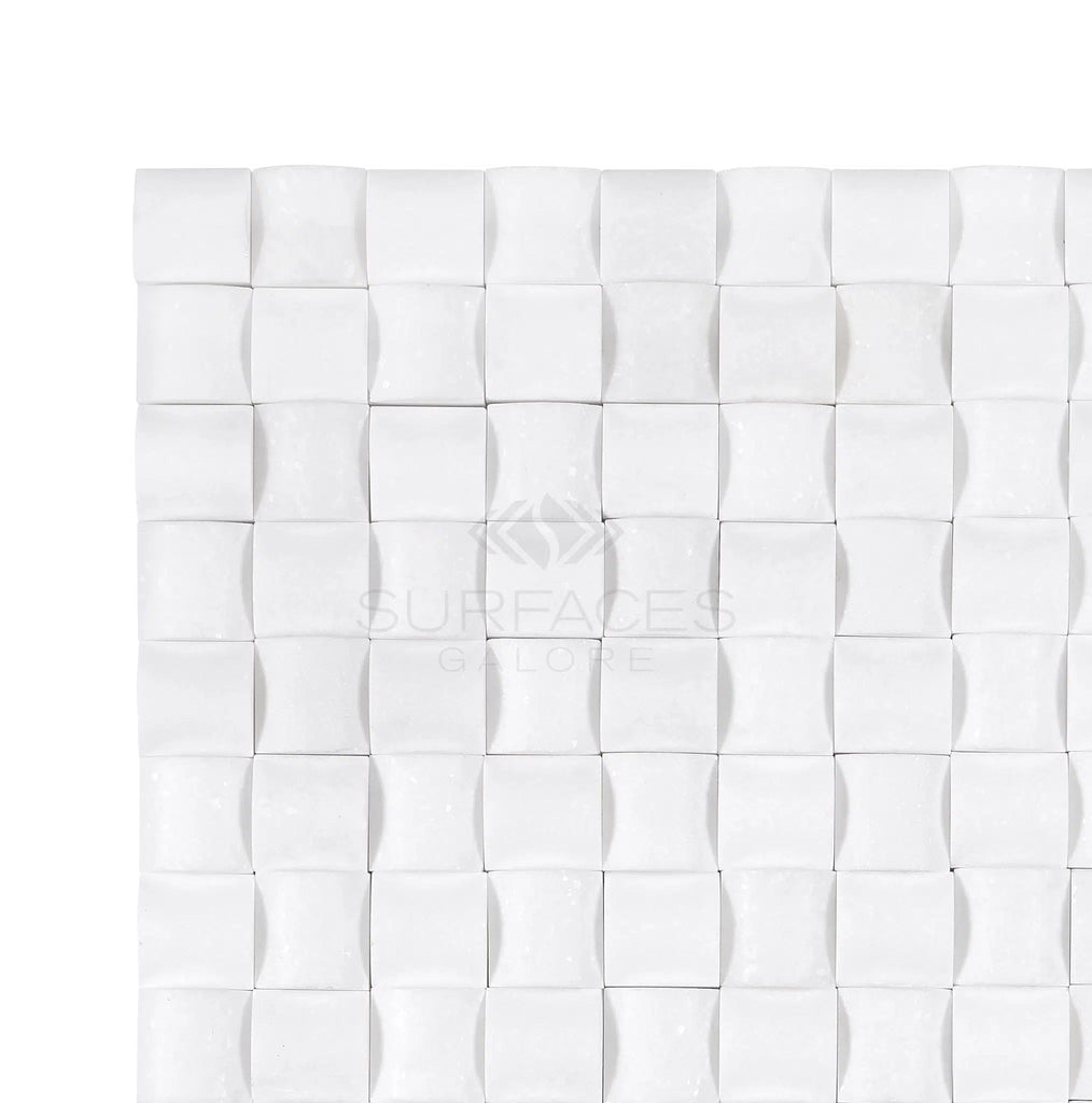 Thassos White (Greek) 3-D Small-Bread Mosaic Marble Polished-Honed tiles from SurfacesGalore are arranged in a grid pattern, creating a surface galore. The design features a subtle three-dimensional effect, offering a luxurious look that evokes the elegance of Thassos White Marble.