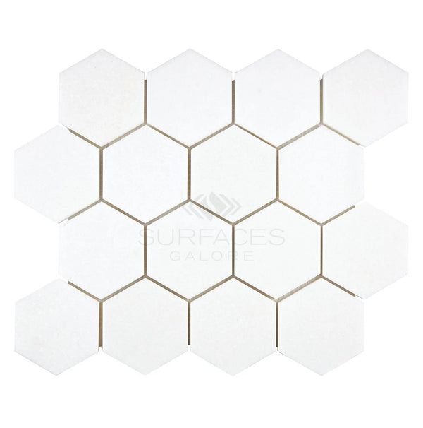 The Thassos White (Greek) 3X3 Hexagon Mosaic Marble Polished-Honed tiles from SurfacesGalore, arranged in a honeycomb pattern, provide a luxurious appearance on any flat surface.