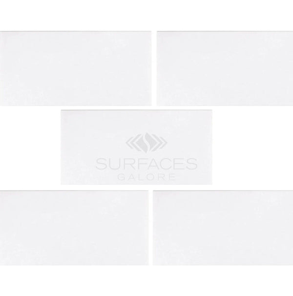 Five Thassos White (Greek) 3X6 Marble Polished-Honed tiles, showcasing a crystalline texture, are arranged with the SurfacesGalore logo in the center.