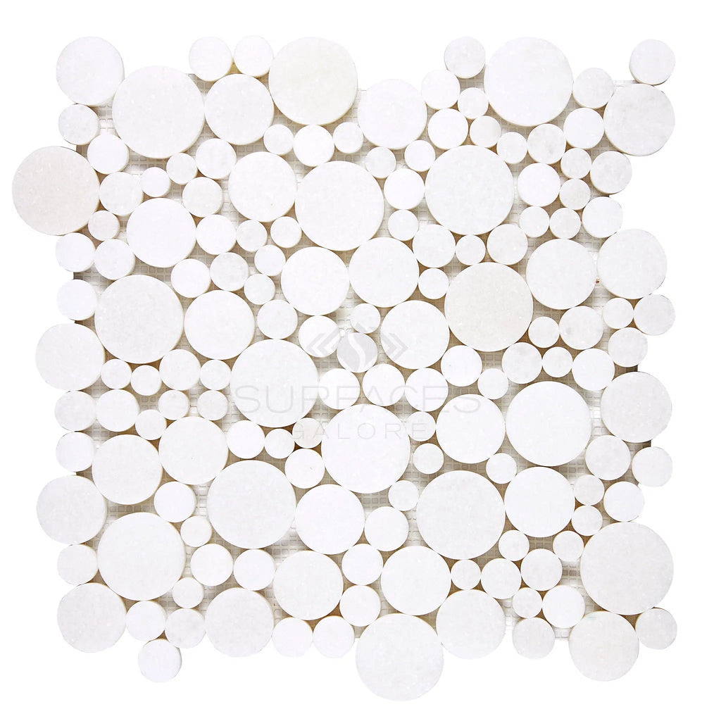 The Thassos White (Greek) Bubbles Mosaic Marble Polished-Honed by SurfacesGalore features a luxurious look with its variously sized circular tiles arranged closely together in a square formation.