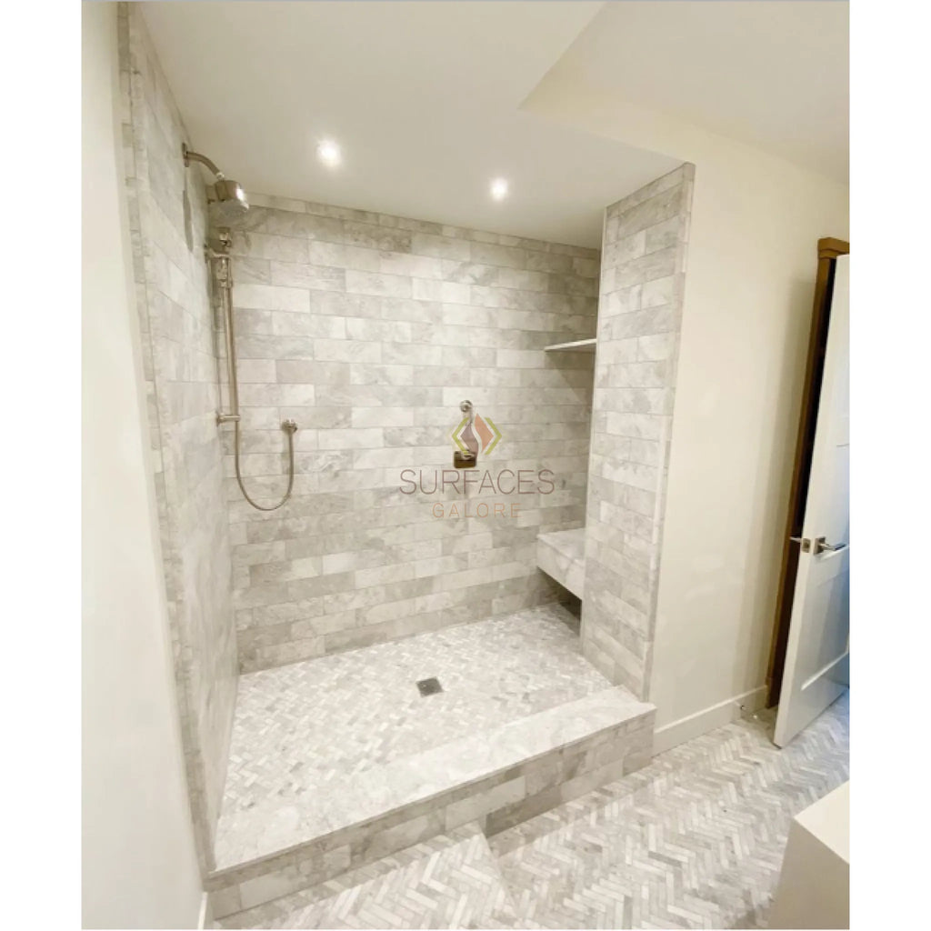 Marble-tiled walk-in shower featuring Bianco Congelato Basketweave with Black Mosaic Dolomite