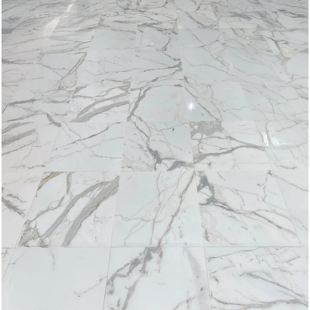 Calacatta Gold 1X2 Diamond Rhomboid Mosaic Marble Tile displayed on a white marble floor