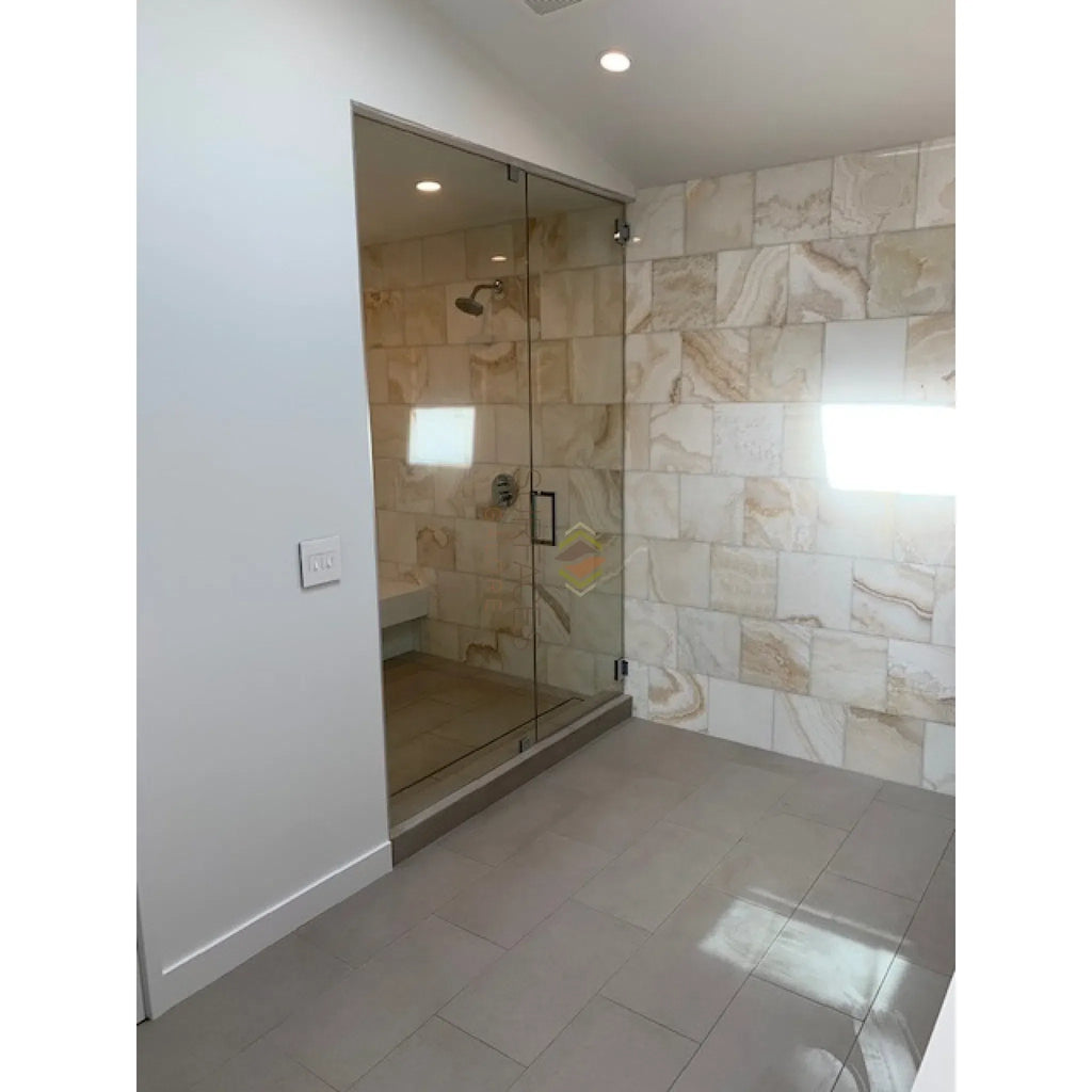 Modern glass shower enclosure featuring Calacatta Gold 2’’ Vortex Hexagon mosaic tile