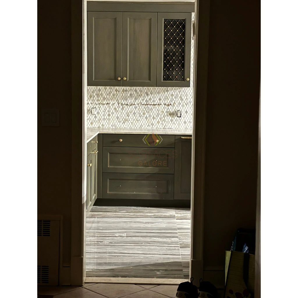 Gray kitchen cabinets complemented by Calacatta Gold 2X4 Brick Mosaic Marble Tile