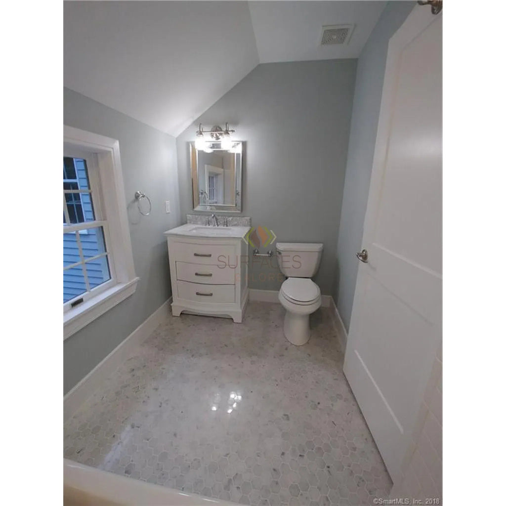 Bathroom interior featuring Carrara White 1’’ Hexagon Mosaic Marble Tile with white fixtures