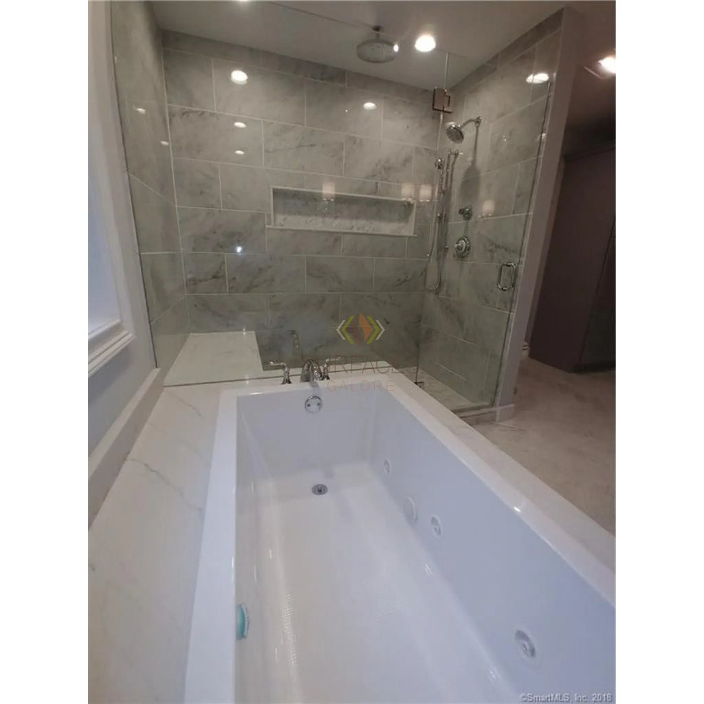 White bathtub with jets paired with Carrara White 1X2 Brick Mosaic Marble Tile