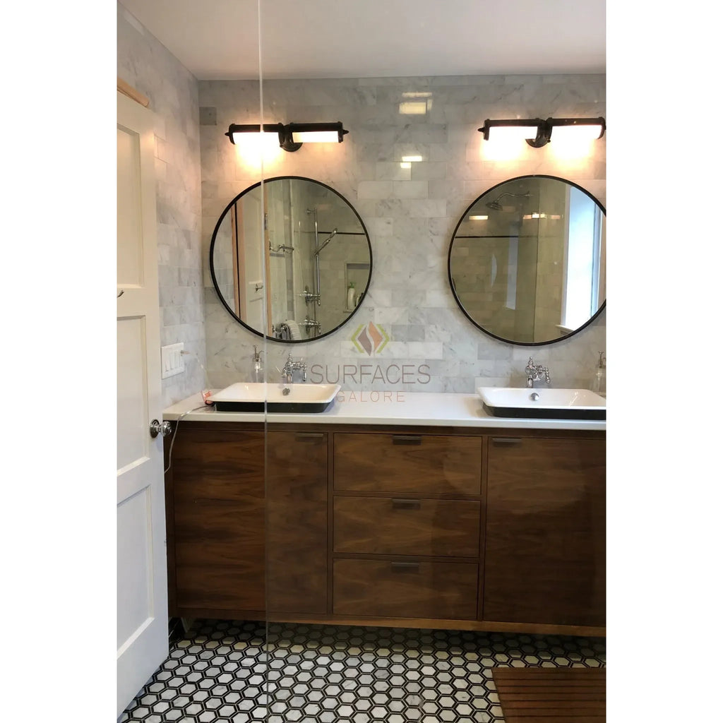 Bathroom vanity featuring dual sinks and Carrara White marble tile design