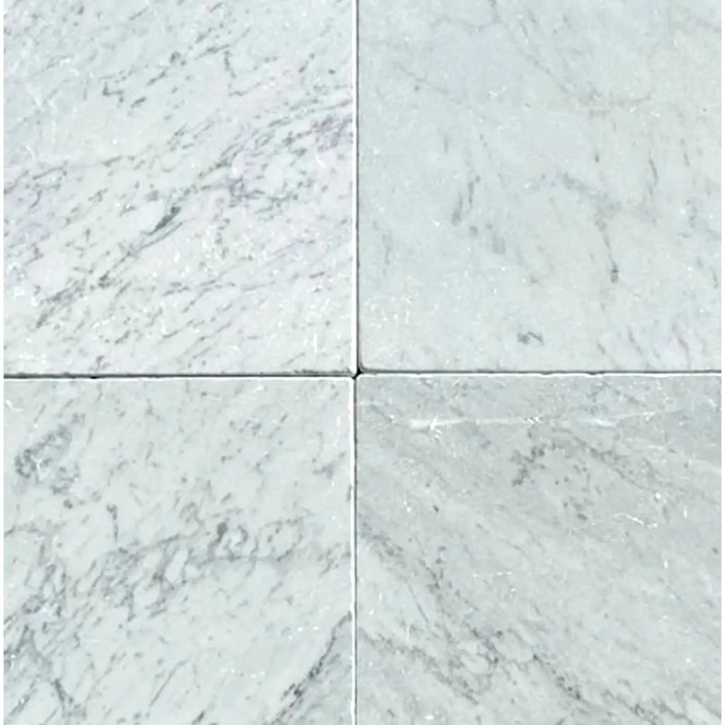 Four Carrara White Marble 12X12 Tumbled tiles showcasing elegant design