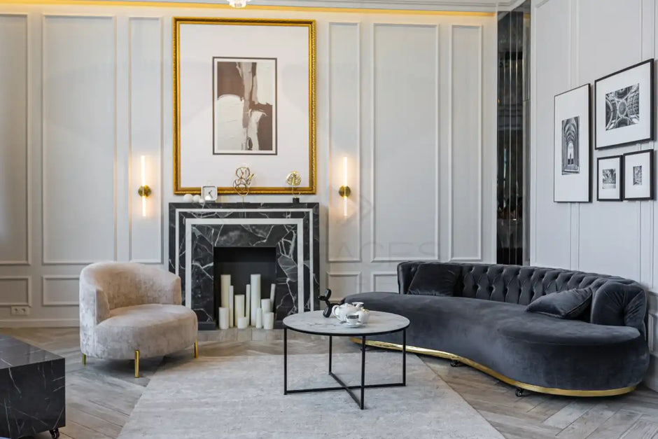 Elegant living room with gray walls, a black marble fireplace, modern artwork, and stylish furniture including a curved sofa.