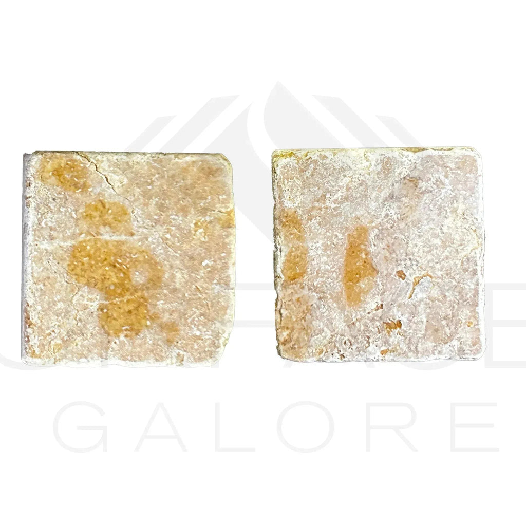 Two square textured soap bars on Giallo Reale Marble Tumbled Tile background