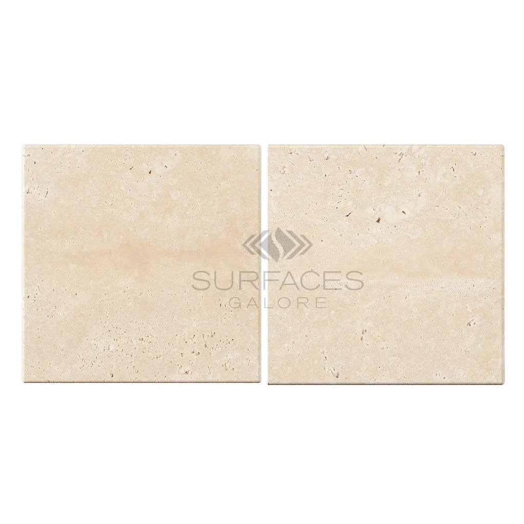 Two beige travertine tiles from the Ivory Light Travertine 6X6 Cross-Cut Tumbled collection