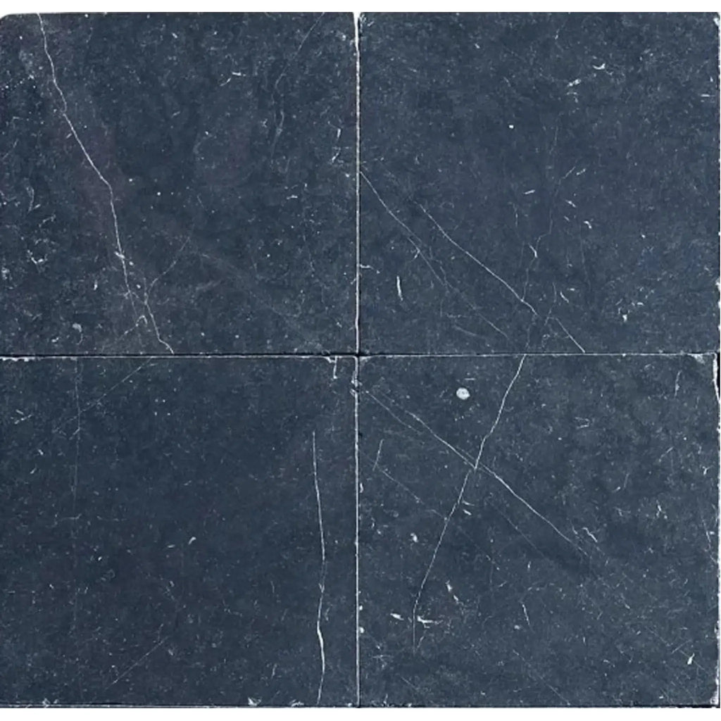 Four dark Nero Marquina Marble 12X12 Tumbled tiles showcasing elegant design