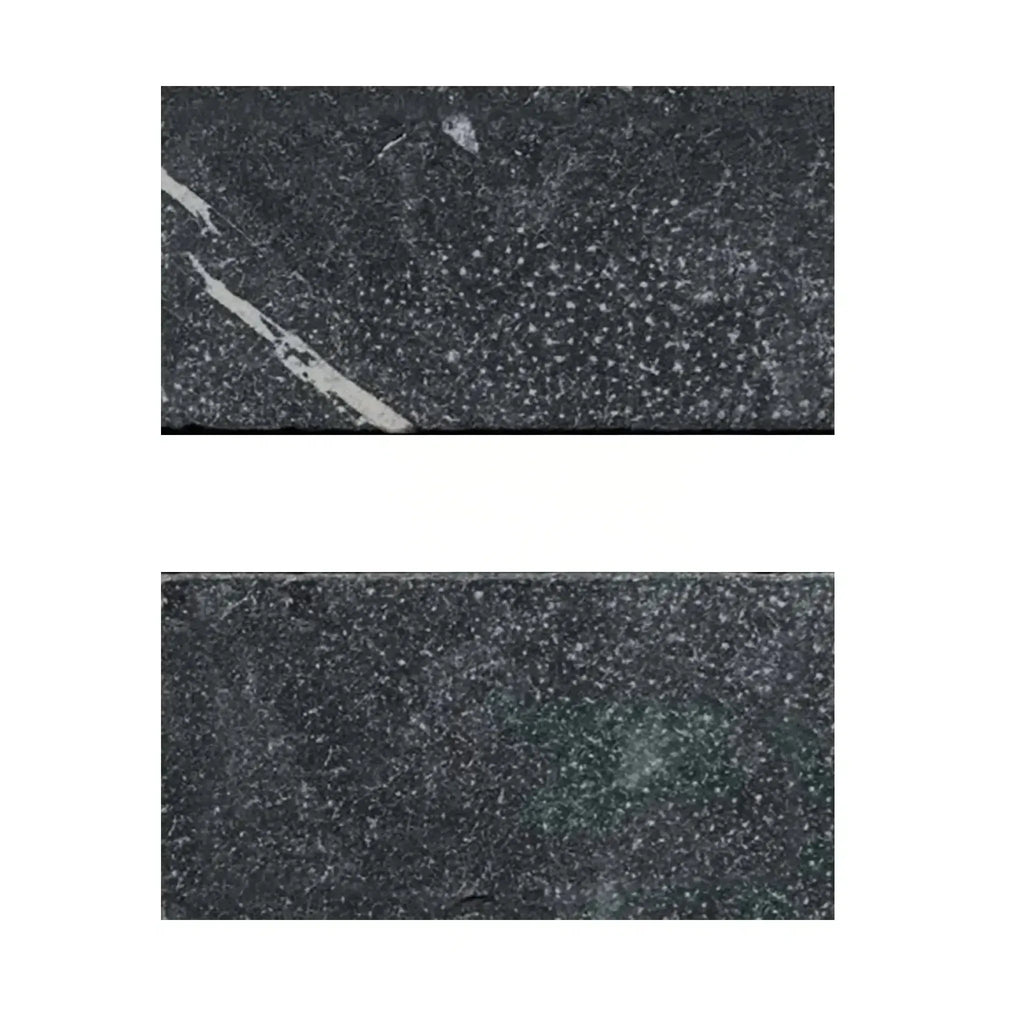 Two dark, speckled Nero Marquina Black Marble 3X6 Tumbled stone tiles