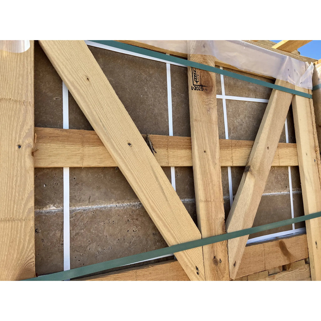 Wooden crate displaying Noce Brown Travertine 18X18 Cross-Cut Tumbled stone slabs