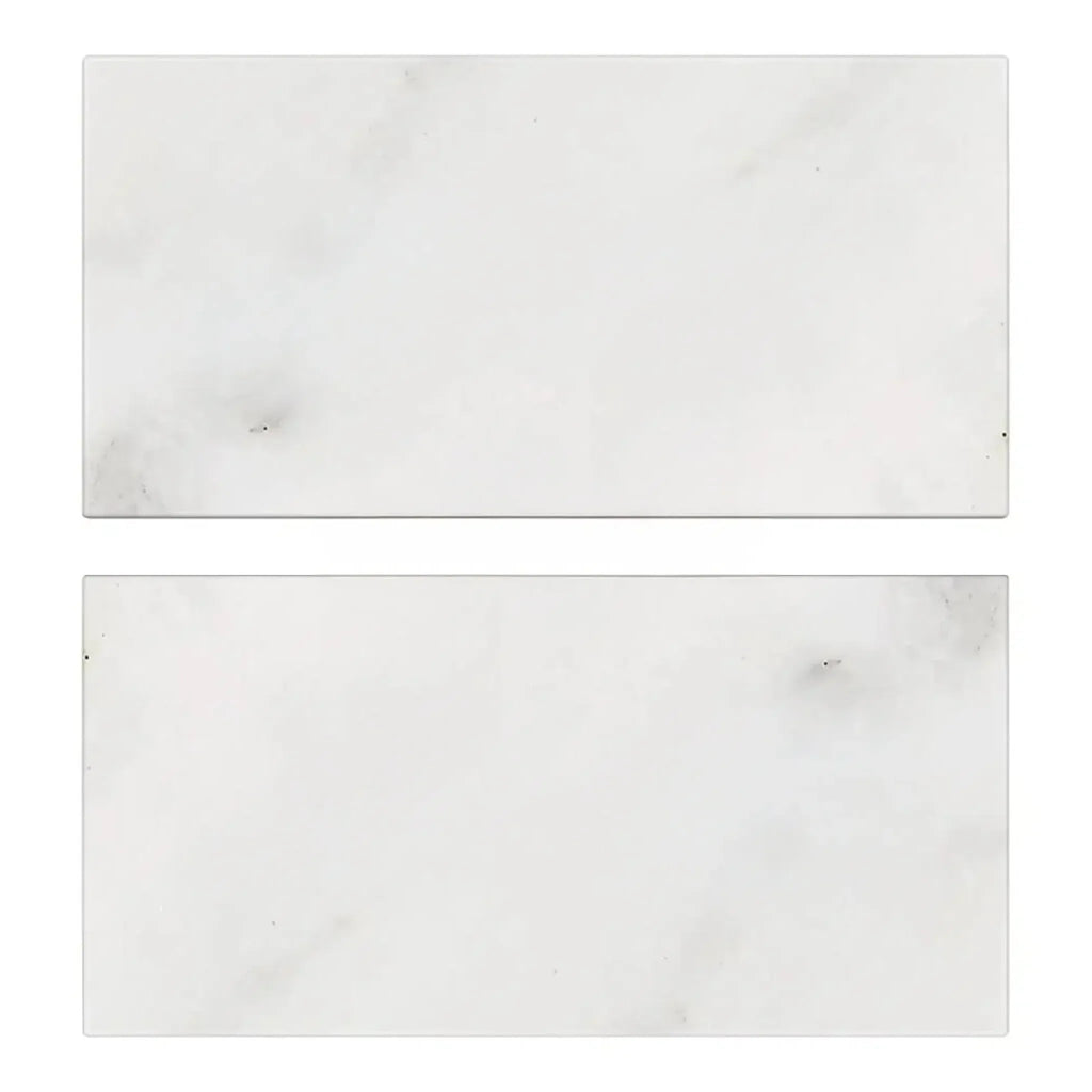 Two rectangular Oriental White Asian Statuary Marble 3X6 Tumbled tiles on display