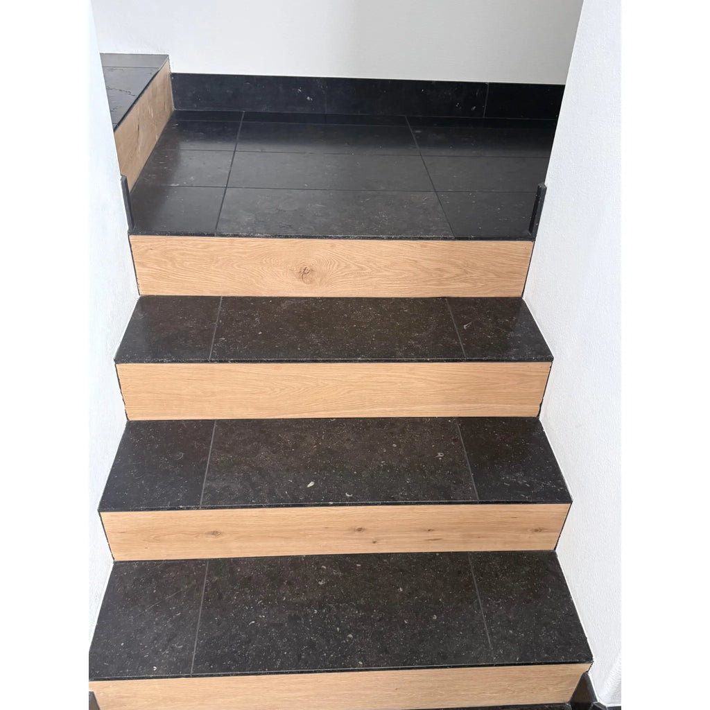 Black and wood staircase featuring Pierre Bleue 12X24 brushed marble tiles