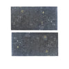 Two dark speckled rectangular tiles from Pierre Bleue 12X24 Brushed Marble collection