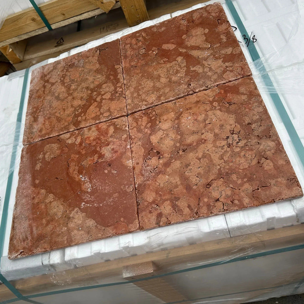 Four red-brown Rosso Verona Marble 12X12 Tumbled tiles in a stylish arrangement