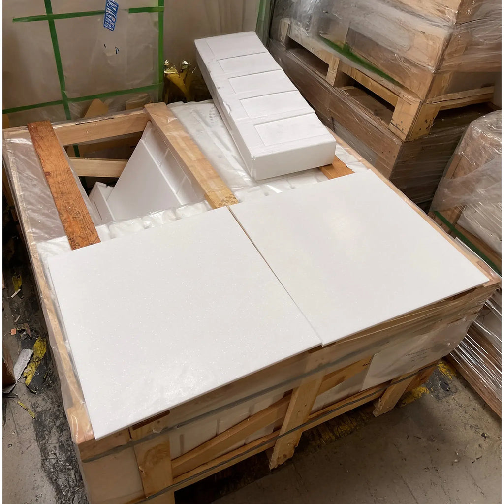 Wooden crate filled with Thassos White tiles featuring a blue-gray Greek key border