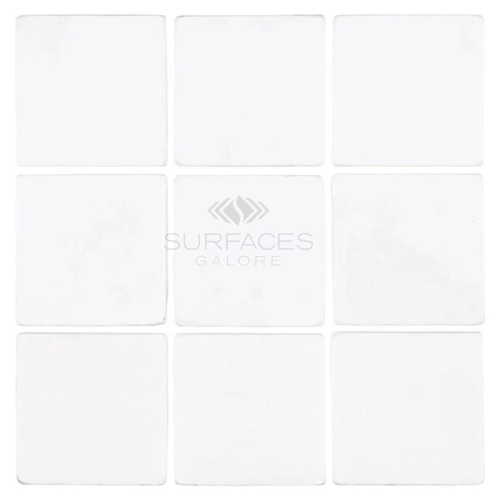 Nine white square Thassos White 4X4 Marble Tumbled tiles arranged in a grid pattern